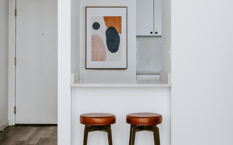 a room with stools and a painting on the wall